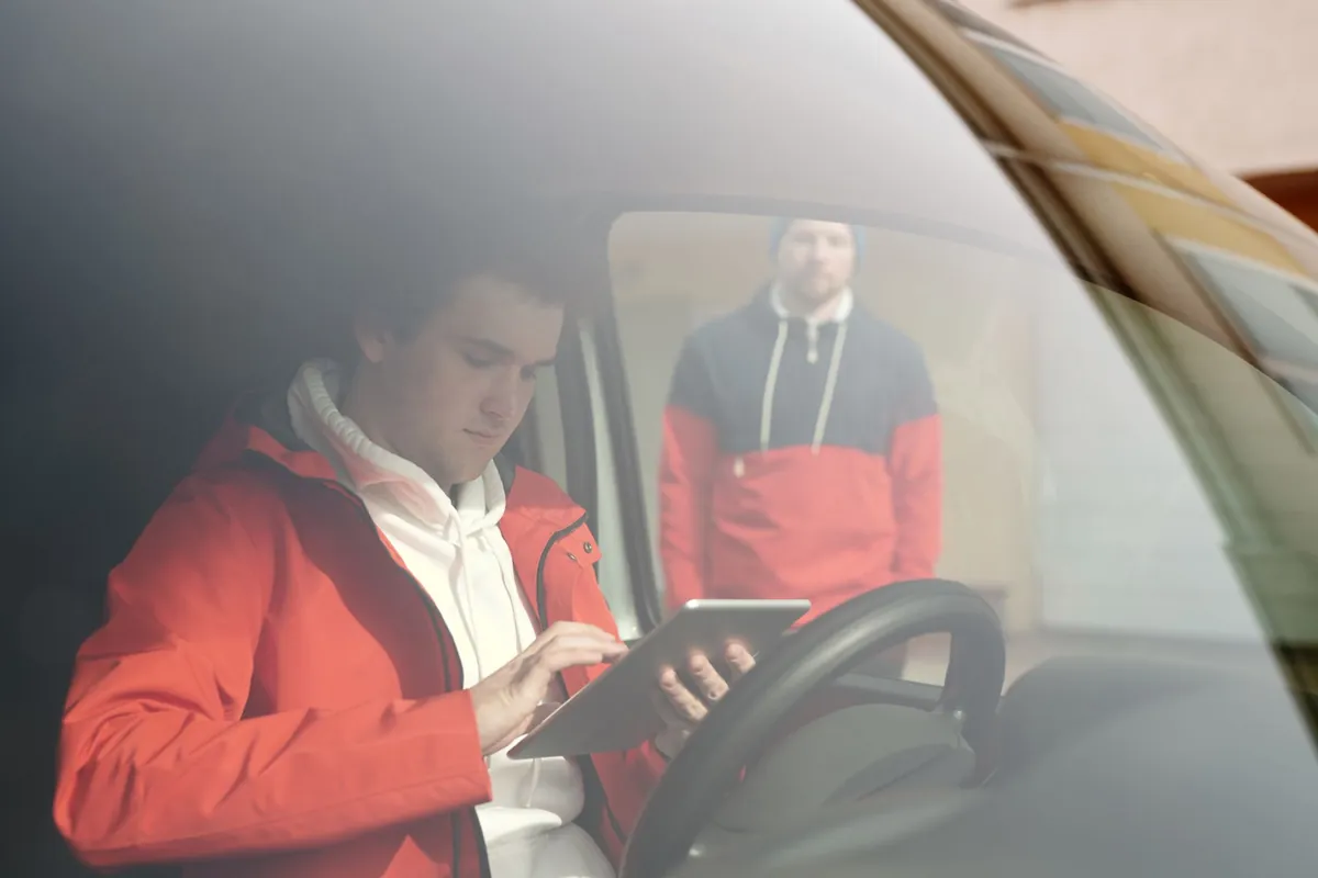 Service technician updating a job on a tablet from the driver's seat of a work van